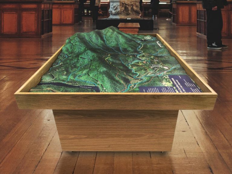 Large 4-foot by 6-foot custom 3D topographical map of the Bent Creek watershed area in North Carolina, created for the North Carolina Arboretum with a white oak shadowbox base and 30-inch-tall podium.