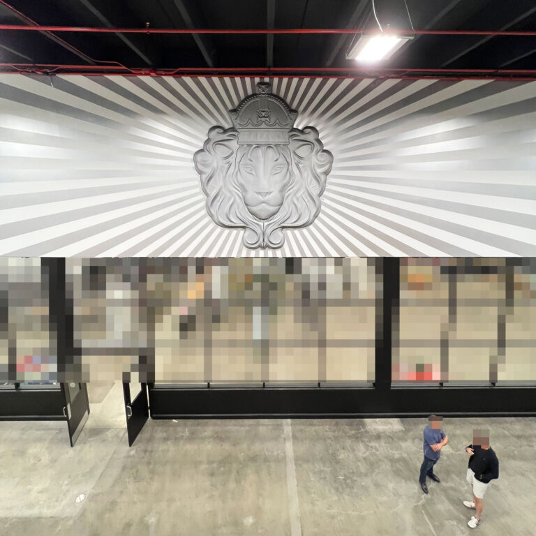 3D bas-relief faux metal lion head logo fabricated for a production warehouse entrance.