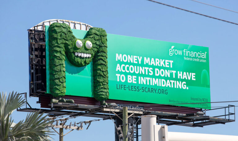 Giant 3D Monster M billboard prop fabricated as a sculptural outdoor advertising display.