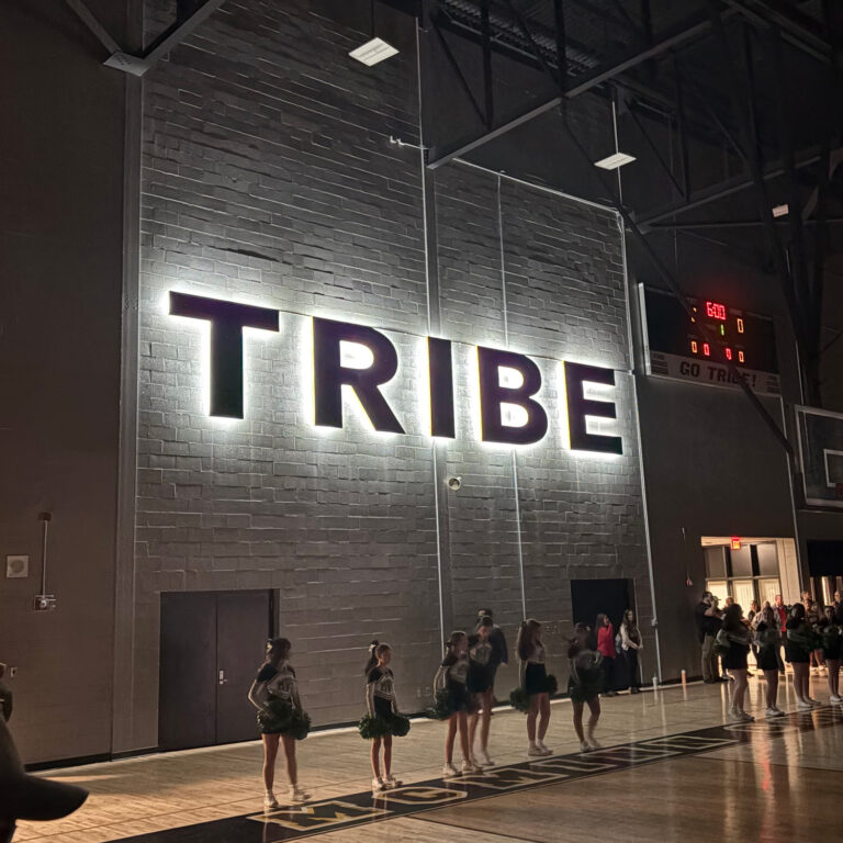 TRIBE school gymnasium lit letters