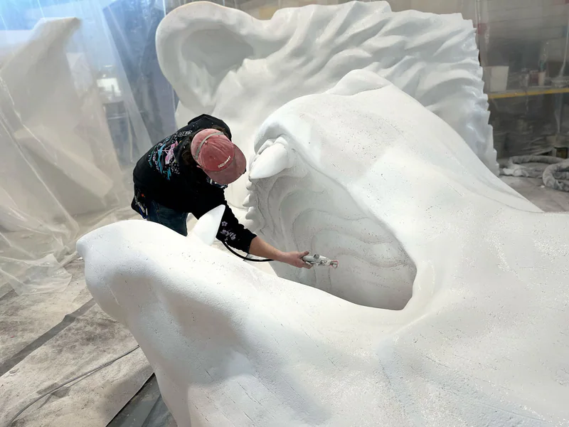 Foam sculpture being sanded and refined.