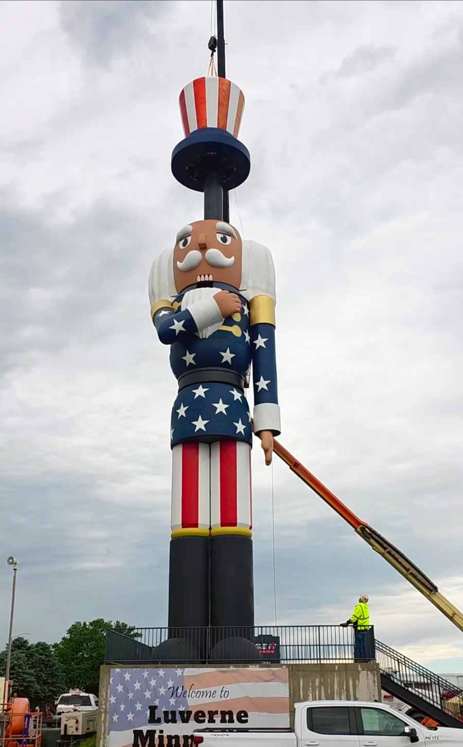 Crane lifting the striped hat section onto the giant nutcracker in Luverne
